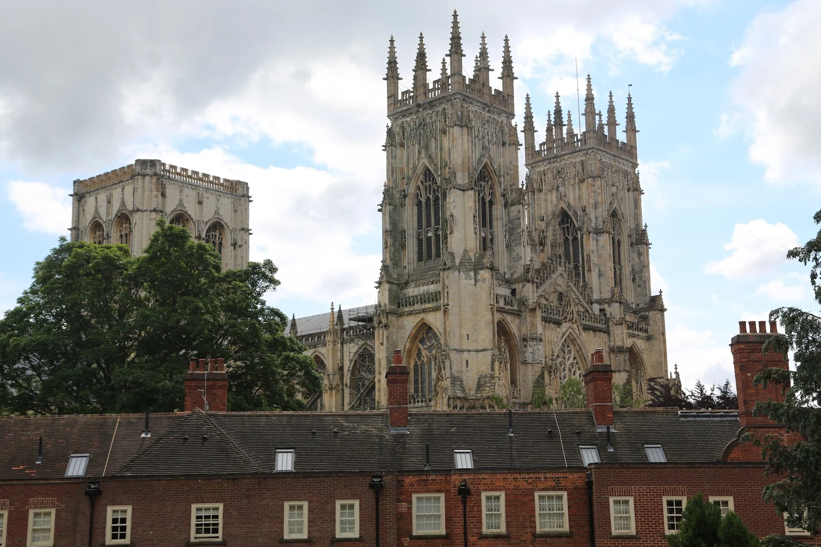 View of York Minster from the side with terraced buildings in the foreground and tree - one of the best places to travel solo in europe