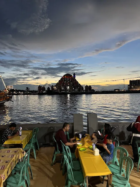 small warungs with 99 mosque dome in background at sunset