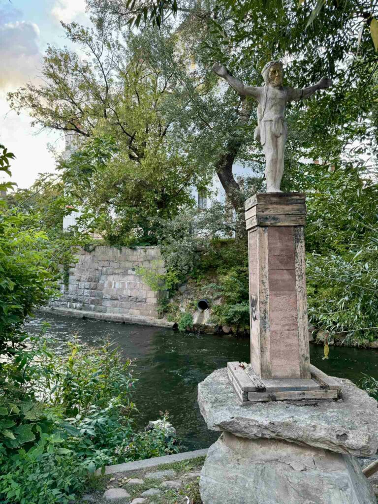 Statue of a man with his arms out in Uzupis