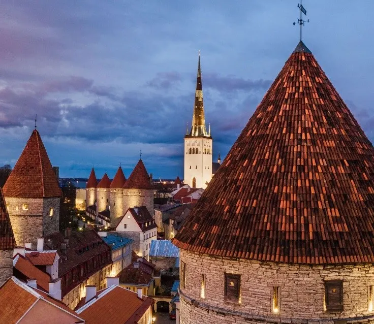 Red roofs and towers of the Old Town of Tallinn visible against an evening sky.