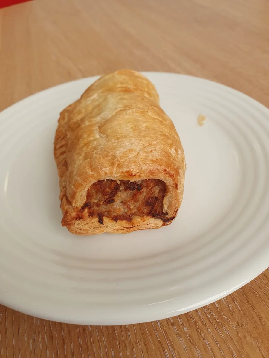 sweet chili infused sausage meat wrapped in puff pastry on a white plate