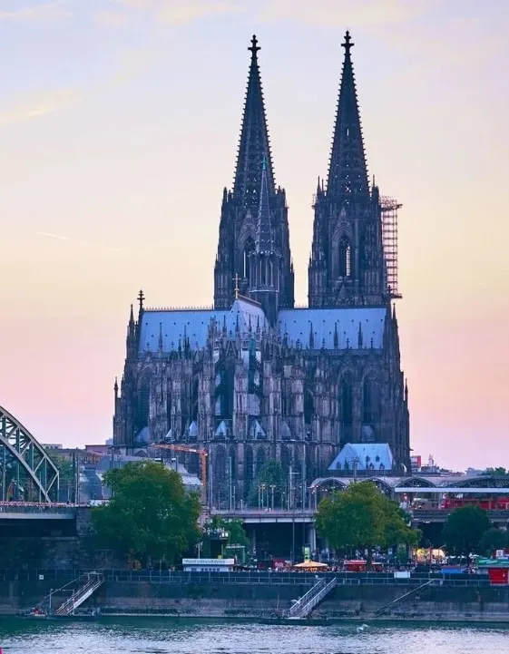Cologne cathedral seen by River Rhein against a dimming sky.