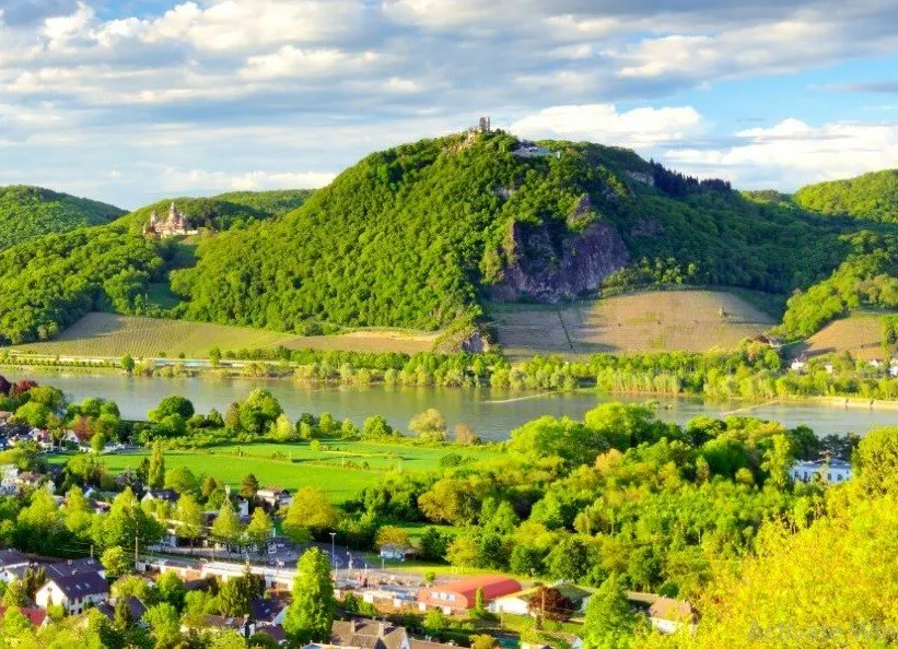 A green hill of Drachenfels seen with river Rhein and German countryside in front of it.