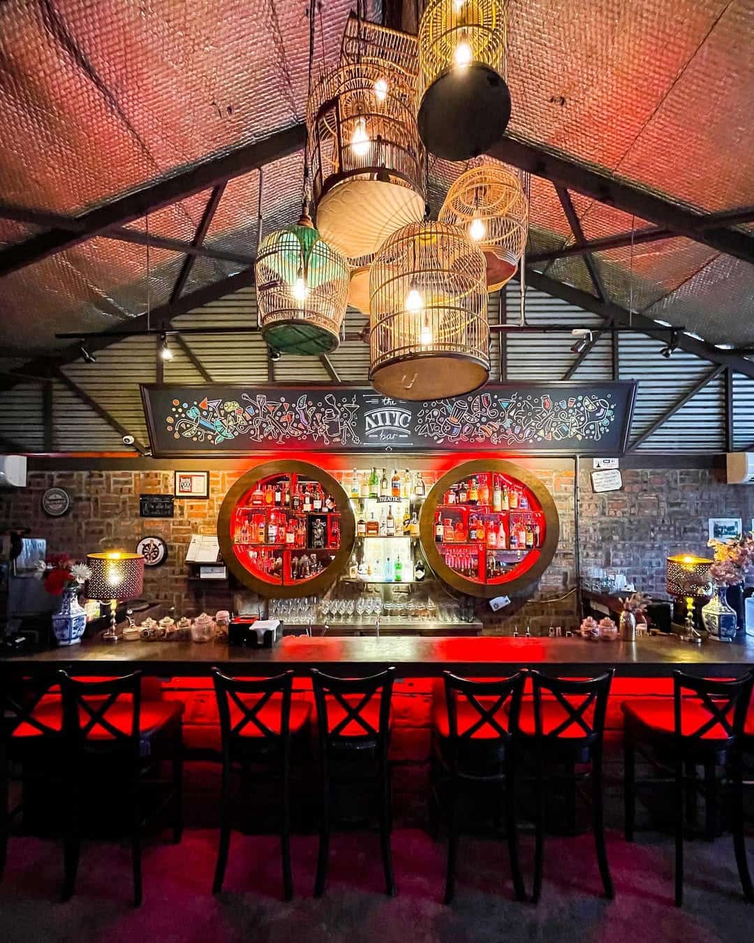 The interiors of this hidden rooftop bar with hanging bird cages and red lighting