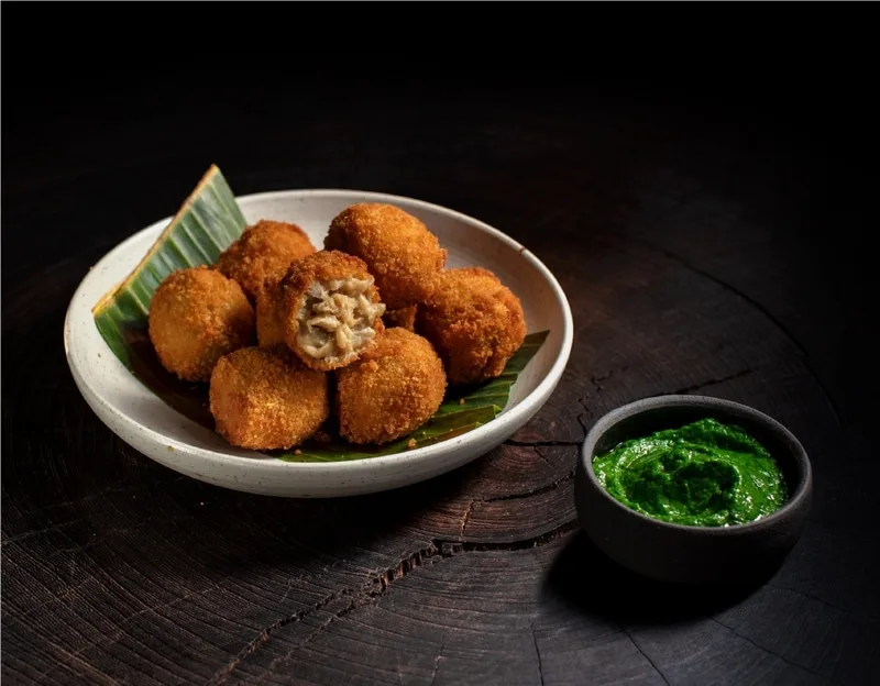Bitterballen in a bowl with sauce next to them