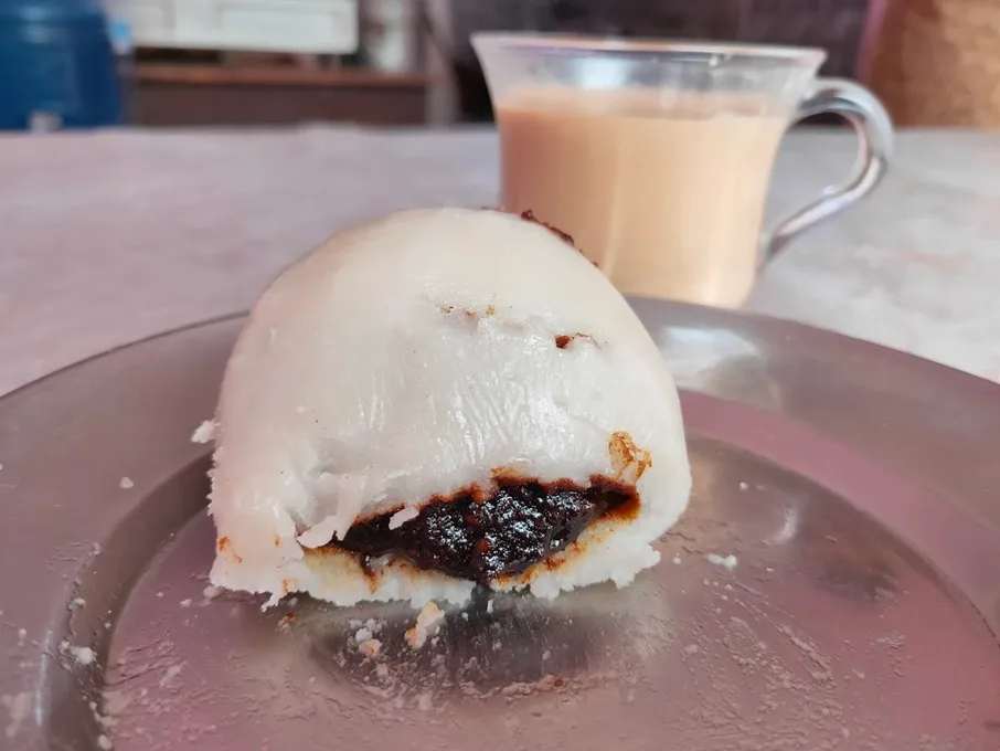 Plate of Nutella yomari next to a cup of tea