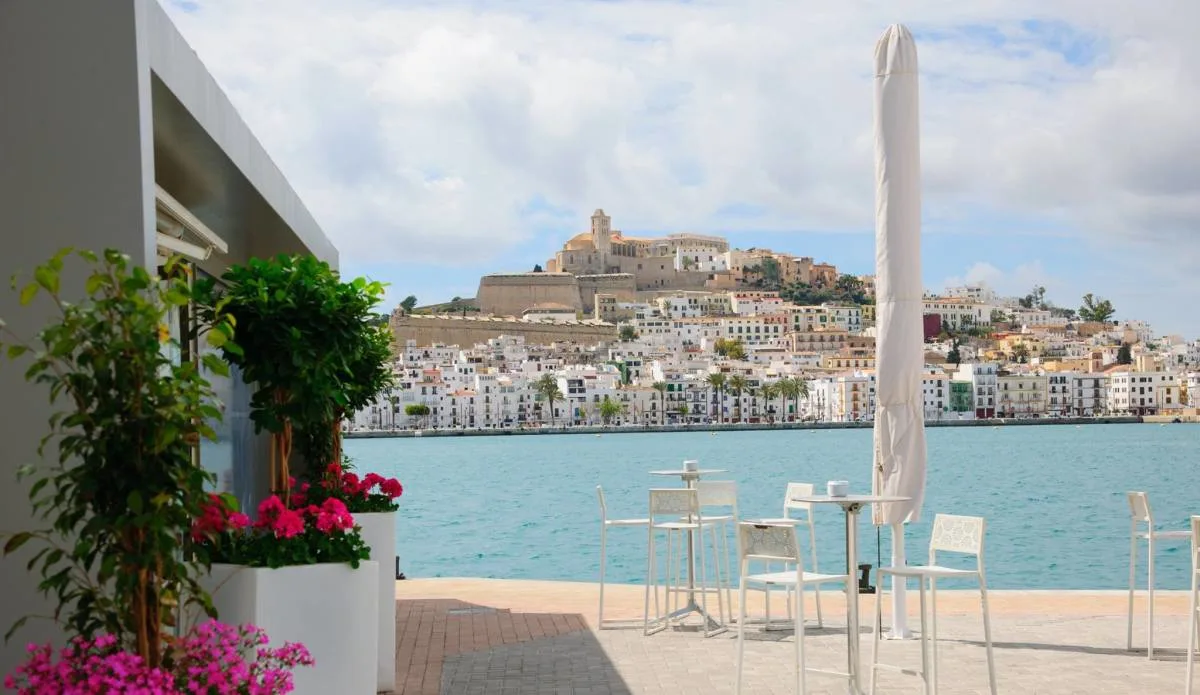 tables spill out of calma restaurant onto the quayside with views of ibiza marina spain