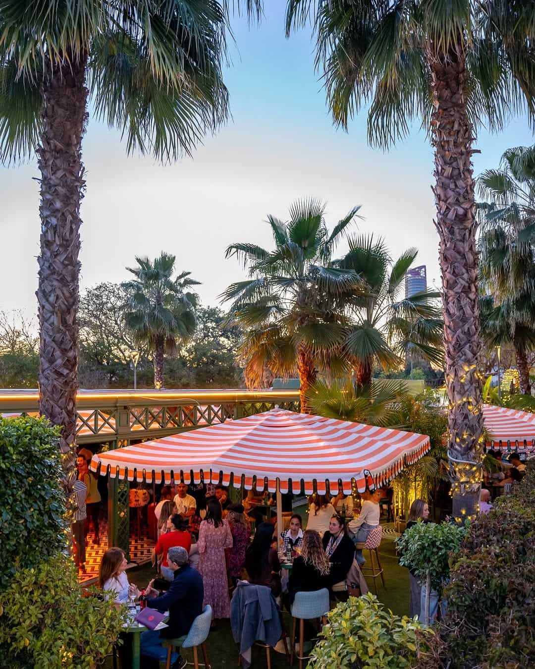 Faena's outdoor setting beneath the palm trees and striped umbrella is the perfect drinking spot