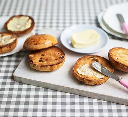 toasted teacakes are a british snack filled with fruit and served with butter and jam
