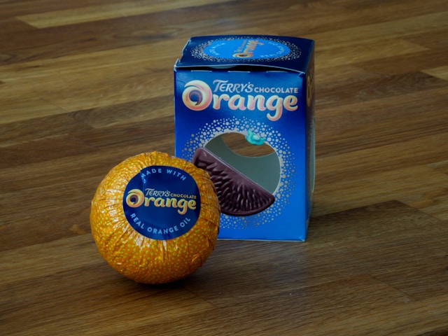 a terry's chocolate orange in an orange foil wrapper next to a blue box