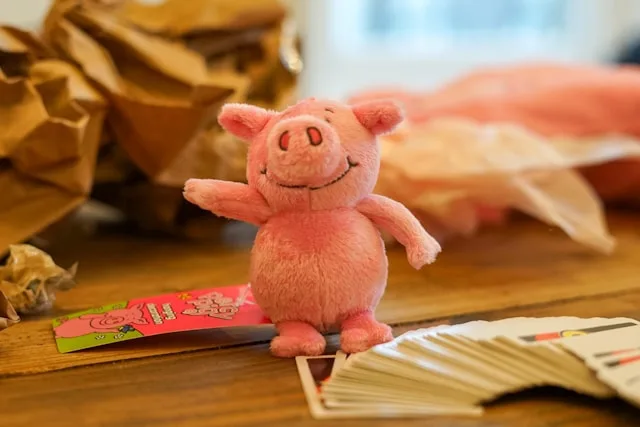 a pink pig shaped stuffed animal is the mascot of marks and specner's british snack percy pigs