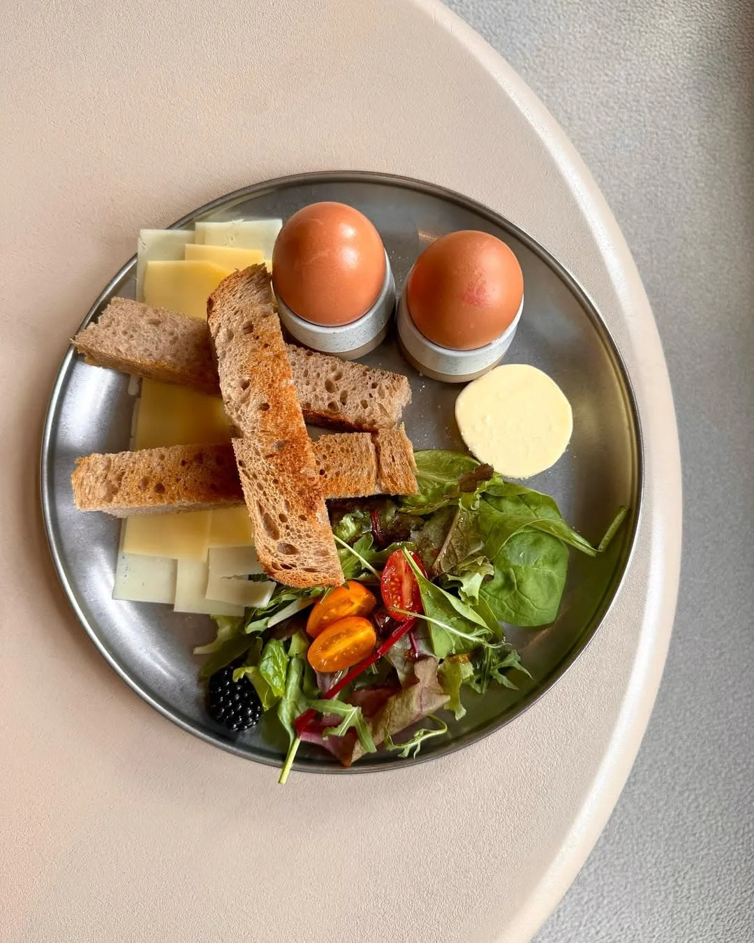 Boiled eggs with egg and soldier toast, cheese and side salad with berries