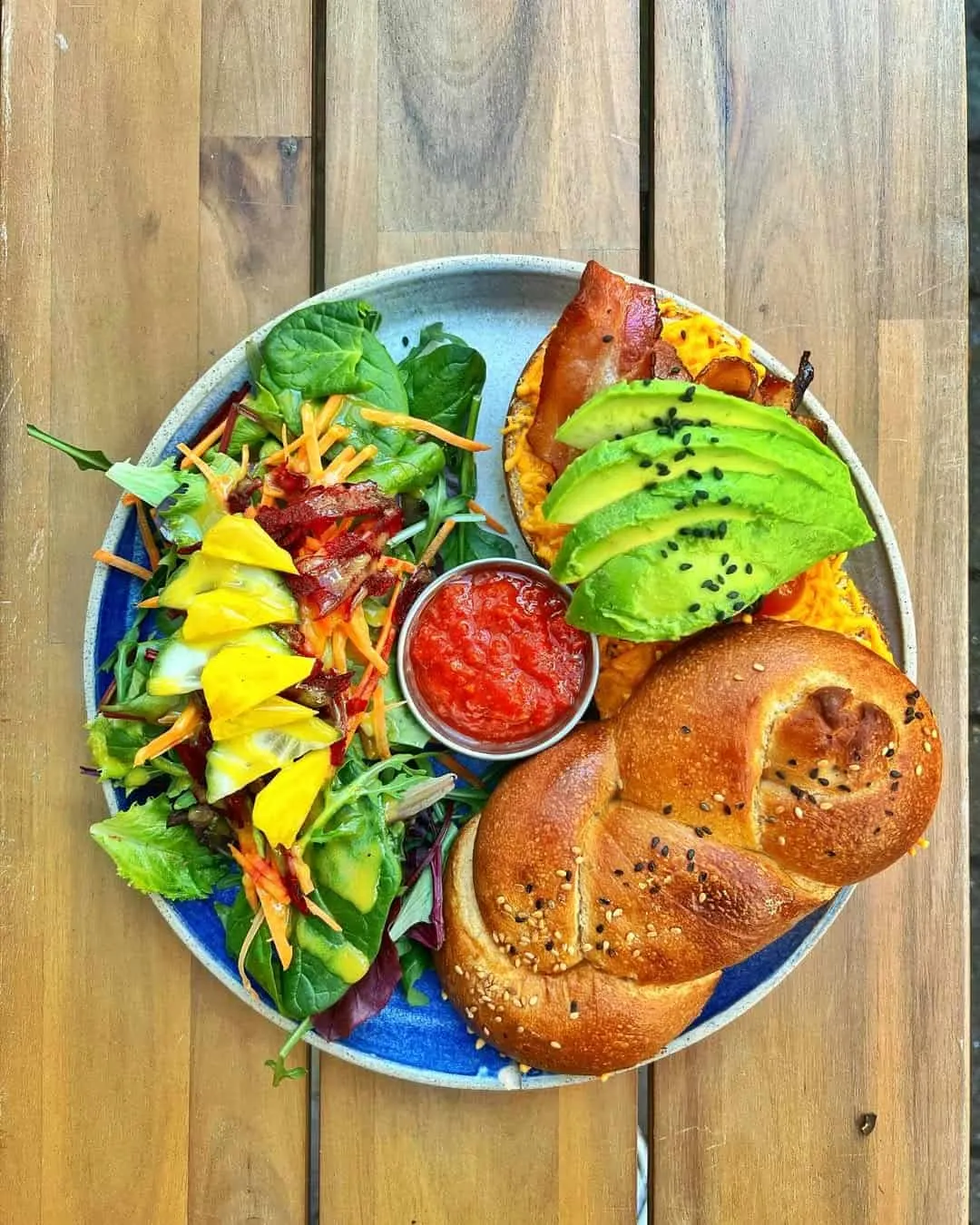 Fresh challahs with maple-glazed bacon, bright, fresh avo, melted cheddar, tomatoes, and a homemade tomato chutney