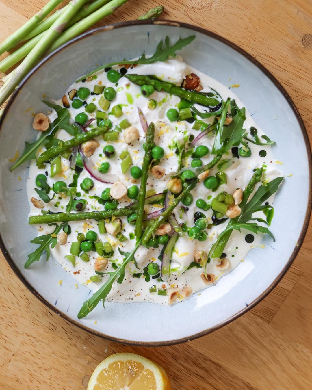 Stracciatella, green asparagus, peas, basil oil, hazelnuts, and arugula