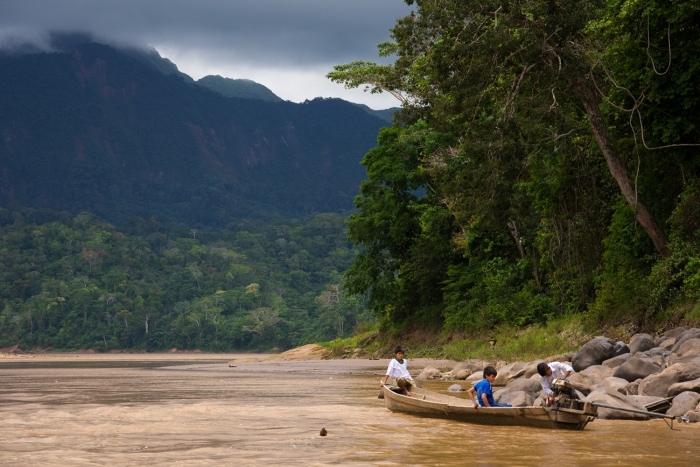 River at Madidi forest with a boat and people on it- a must visit on your 2 week bolivia travel itinerary
