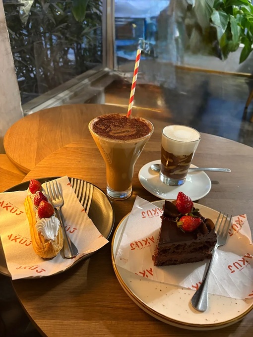 Eclair, chocolate cake, and coffees on a table 