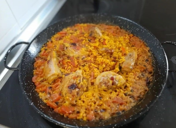 Paella with chicken in a big pan