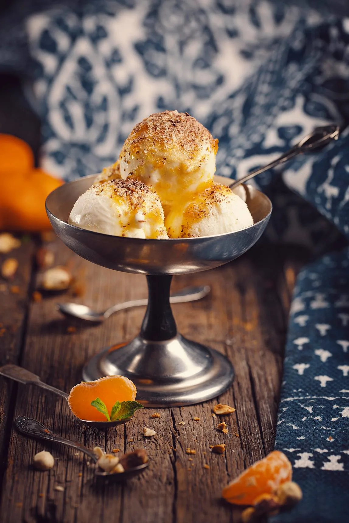 a metal bowl with vanilla sokhumi ice cream topped with tangerine jam and chopped nuts at amra restaurant in tbilisi georgia
