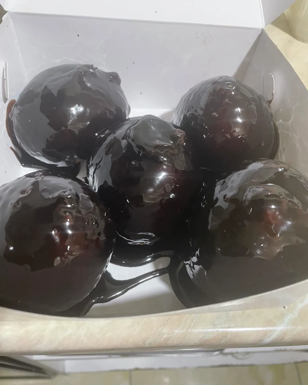 ponchiki donuts covered in dark chocolate sauce