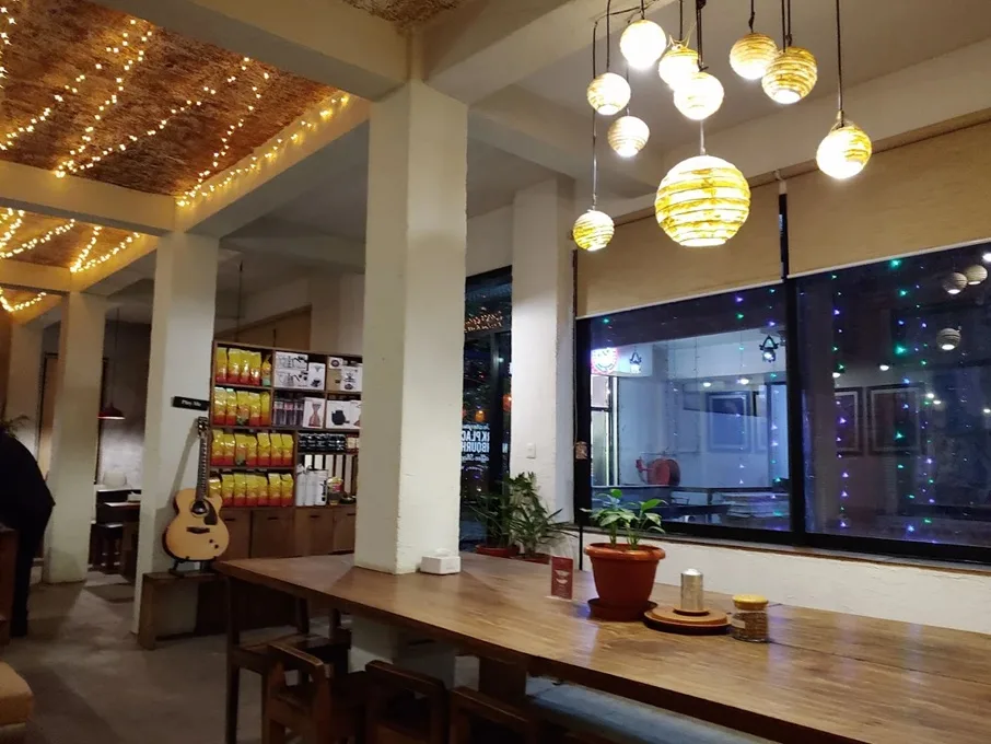 Interior of Himalayan Java coffee shop showing a long table and fairy lights 