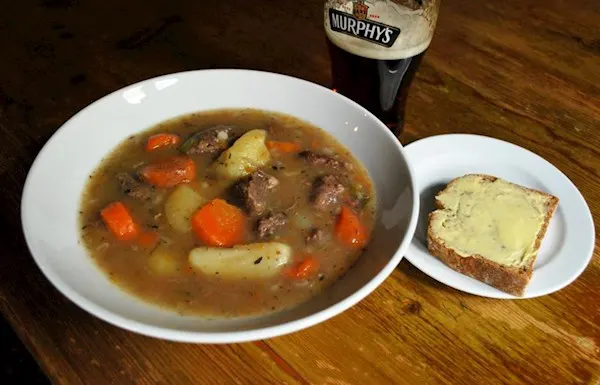 a white bowl containing beef and guinness stew with bread at boxty house restaurant in dublin ireland
