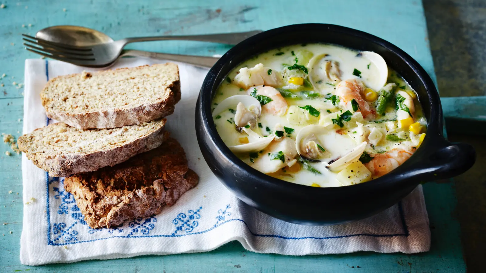 irish seafood chowder in a black bowl with brown bread is a popular street food in dublin