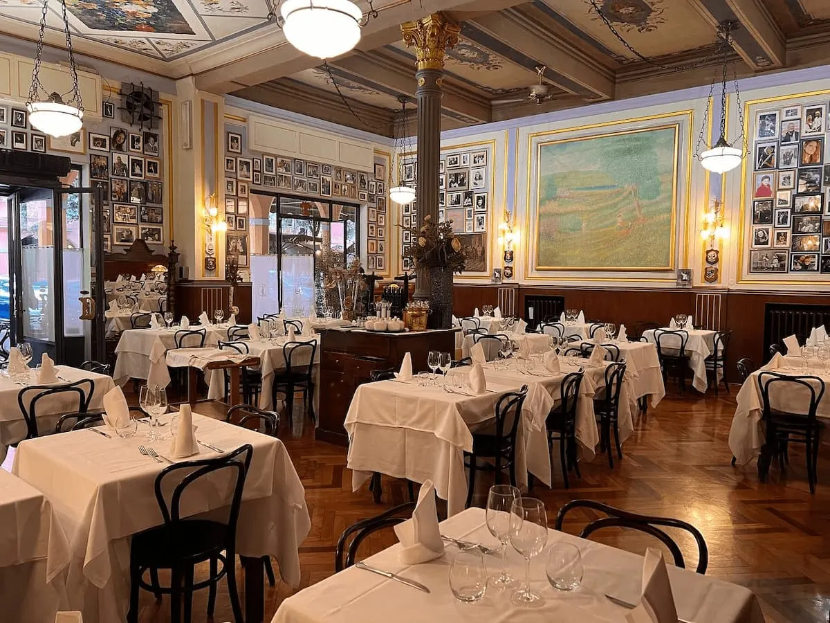 donatello is one of the best restaurants in bologna italy with white table cloths, vintage furnishings and walls covered in art 