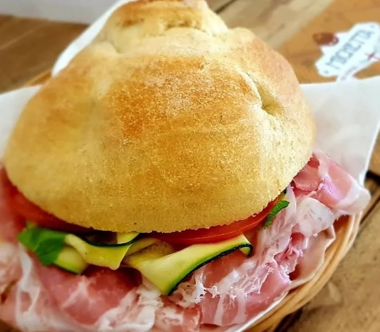 Michetta filled with cured meat, tomato and sliced courgette