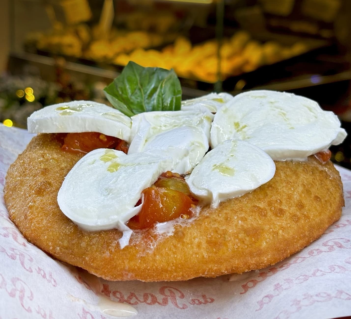 A version of the pizza fritta, deep fried dough topped with mozarella, tomatoes and basil