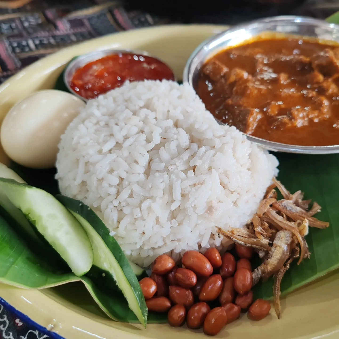 Served with coconut rice, sambal, peanuts and boiled egg, i.e., nasi lemak