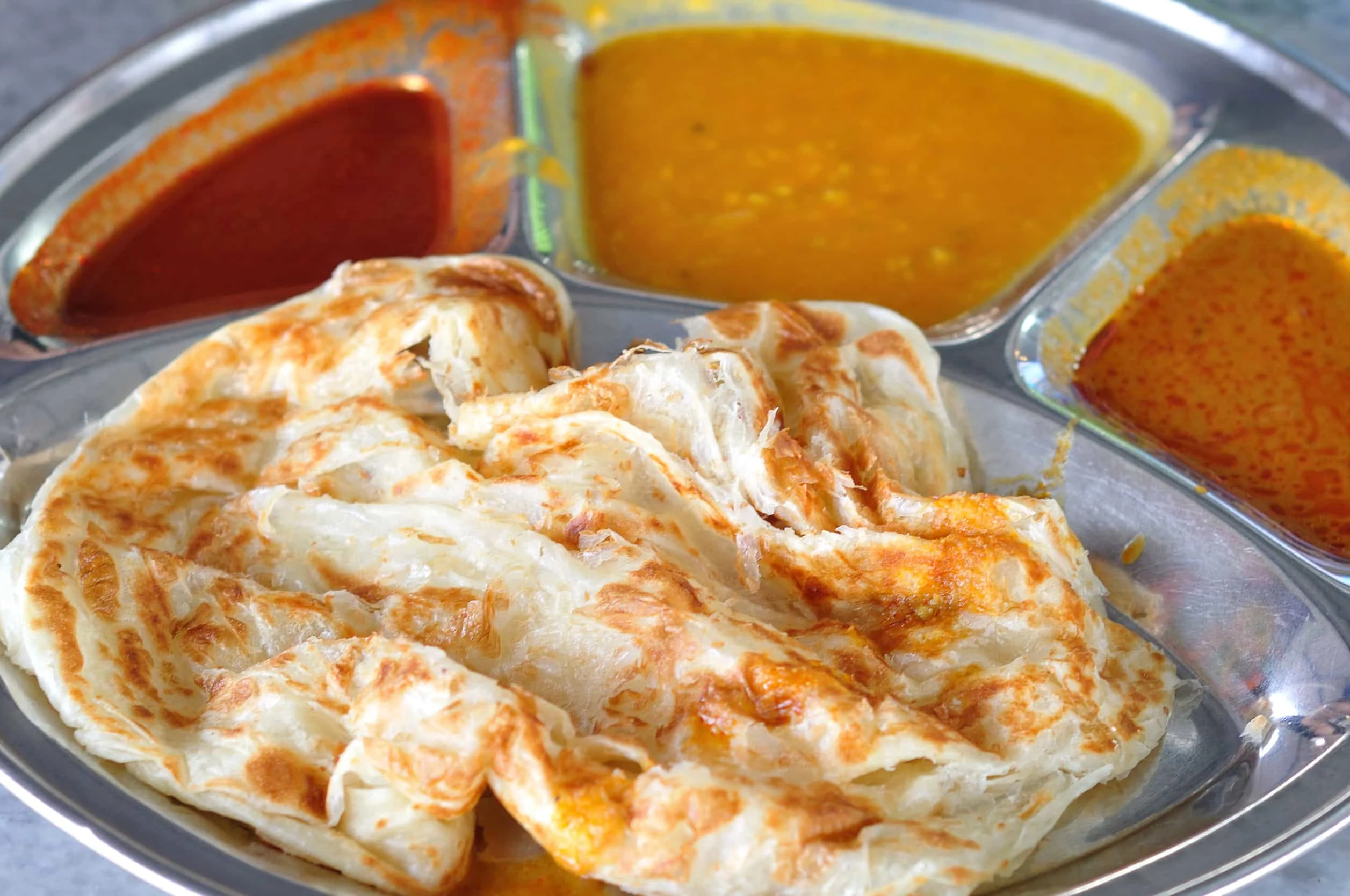 Roti canai is best when dipped in curry or dahl