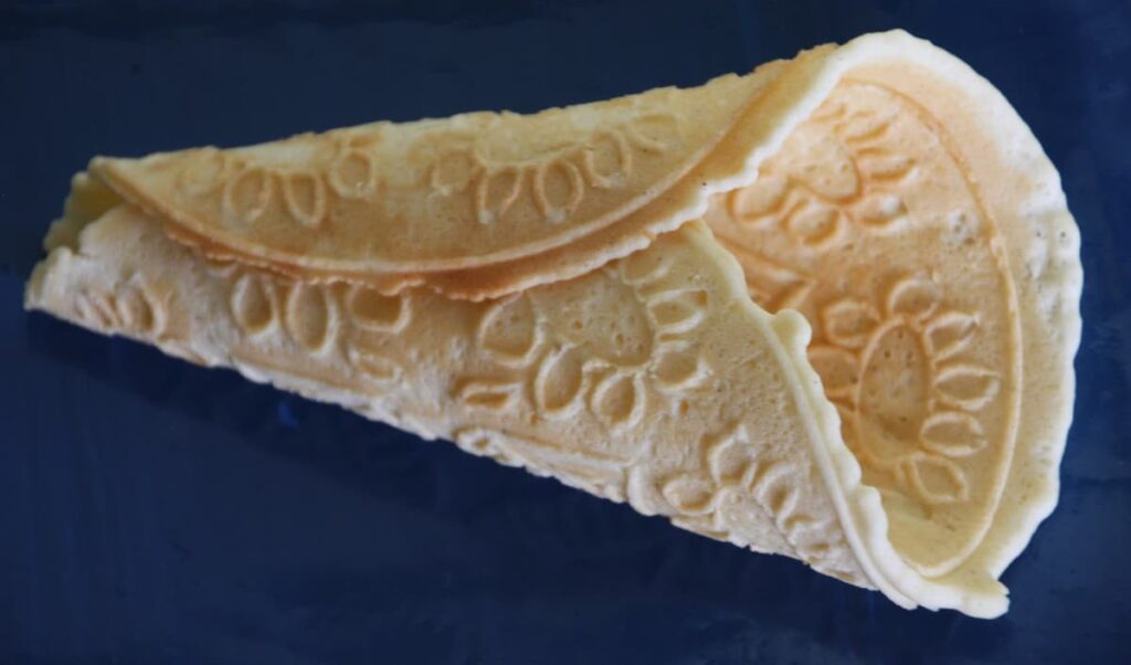 a krumkake is a thin norwegian cookie cooked on a griddle