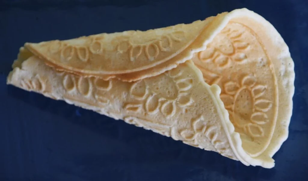 a krumkake is a thin norwegian cookie cooked on a griddle