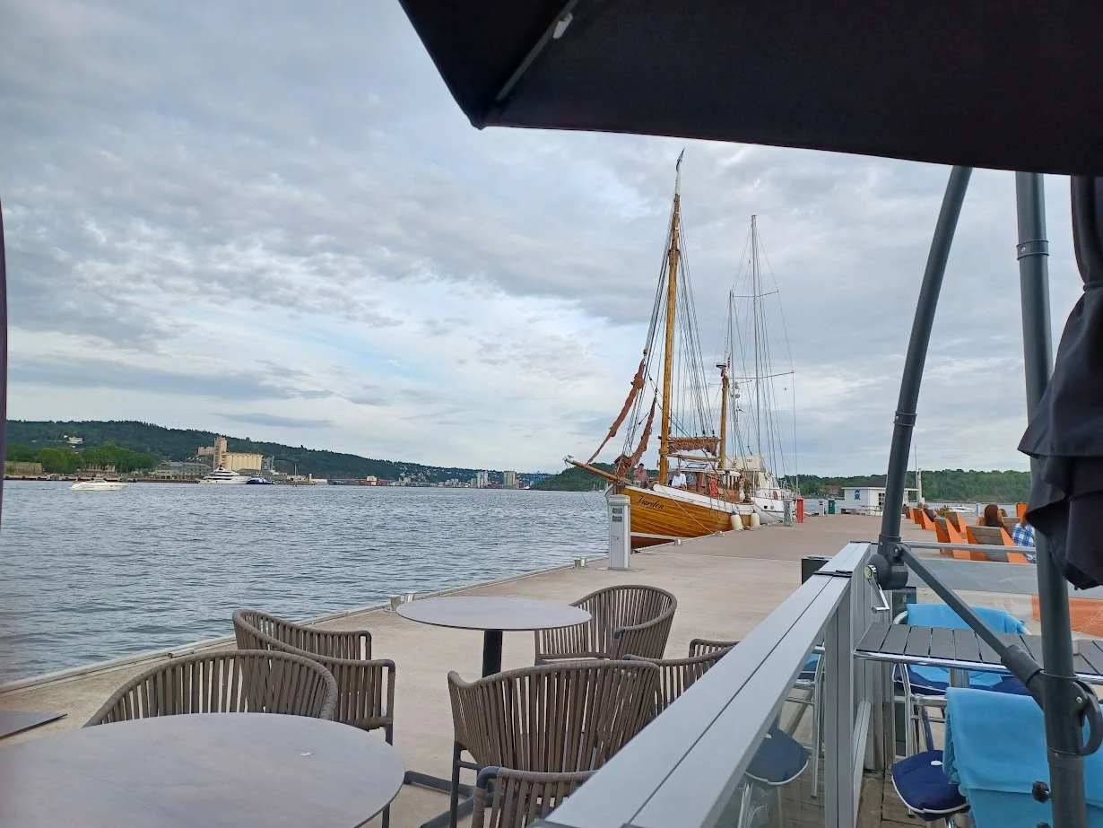 a sailing ship on a pier viewed from brygga bar in aker brygge oslo norway