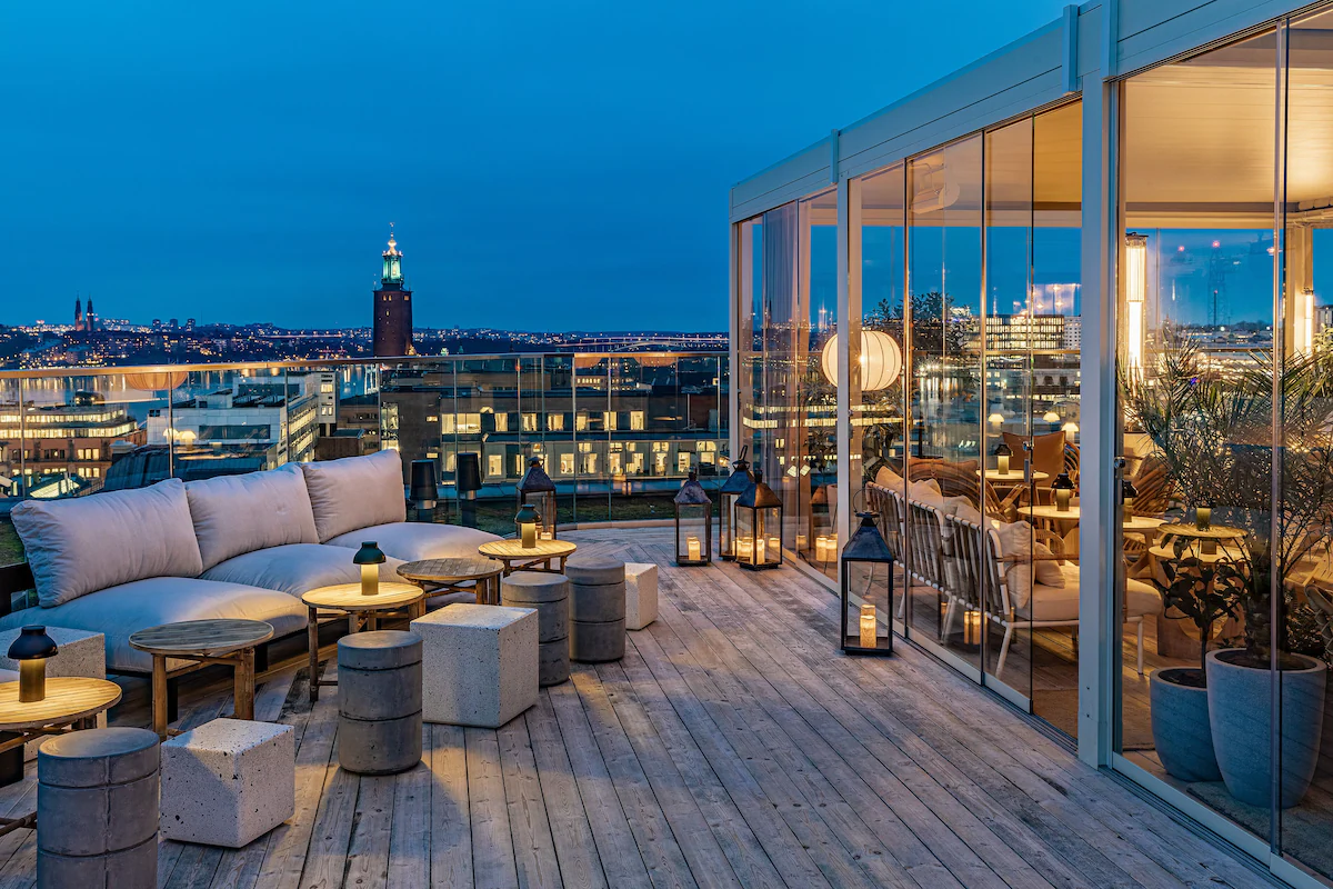 the rooftop terrace of hobo hotel with sofa style seating and tables overlooks the skyline of stockholm sweden