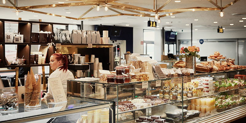 a coffee shop counter with danish pastries in a display cabinet
