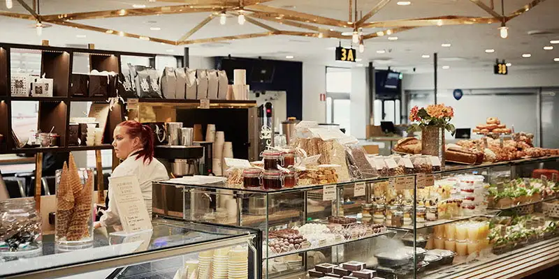 a coffee shop counter with danish pastries in a display cabinet