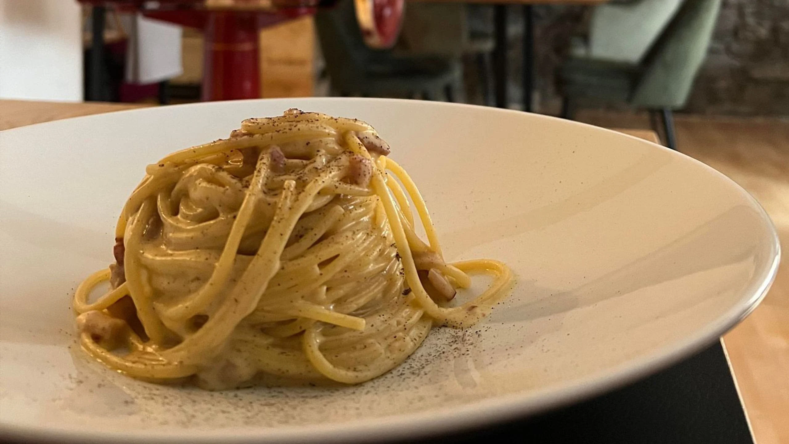 spaghetti carbonara on a white plate at trattoria da rafmi italian restaurant in interlaken switzerland