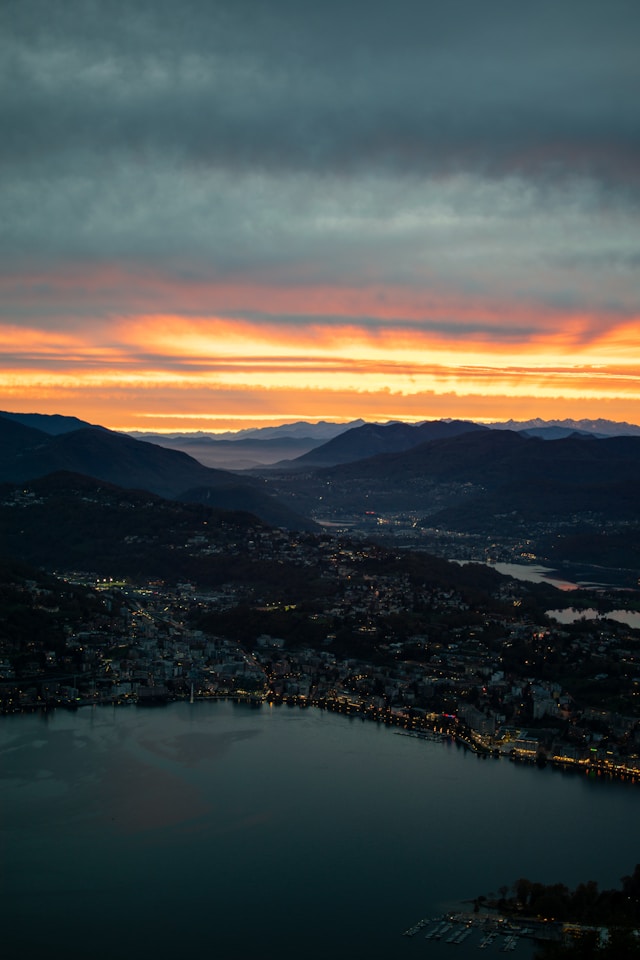 sunset over lake lugano switzerland with lugano city in the background
