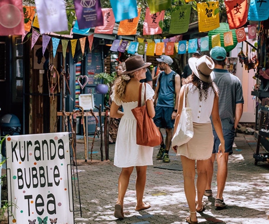 People walking on a small, colorful street at Kuranda