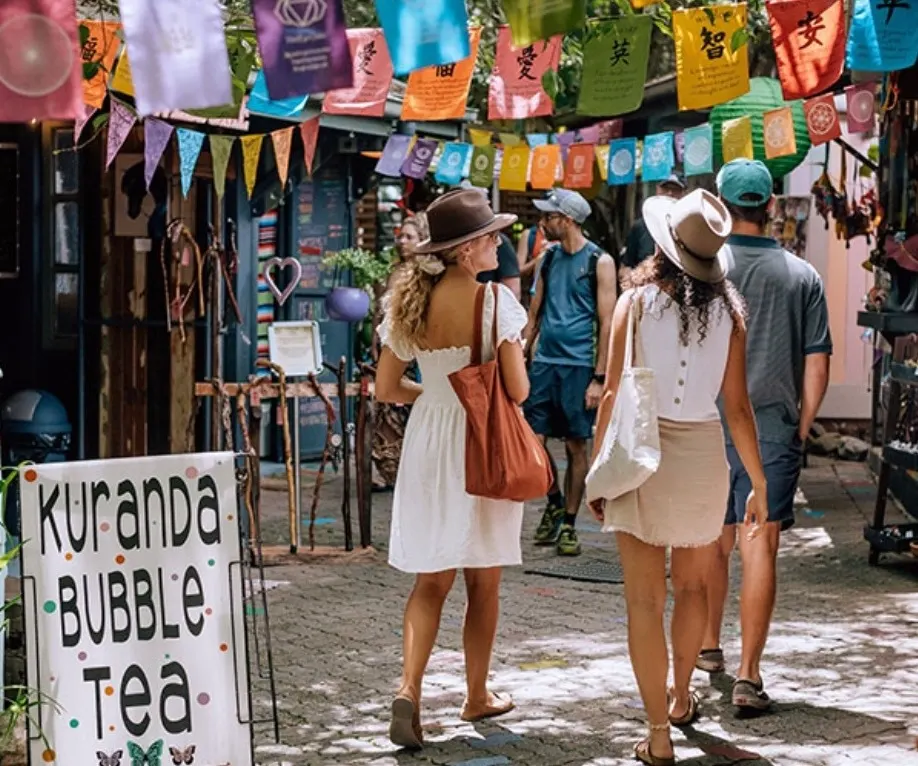 People walking on a small, colorful street at Kuranda