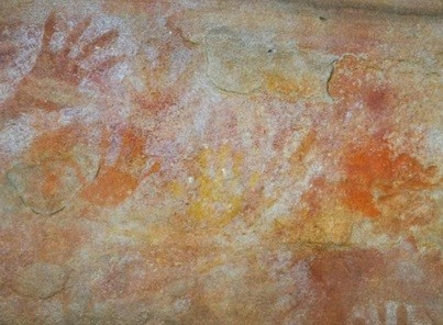 Painted hand prints on a stone wall