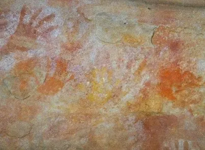 Painted hand prints on a stone wall