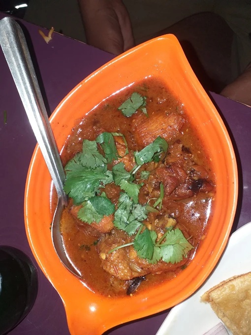 A serving of beef curry in an orange bowl