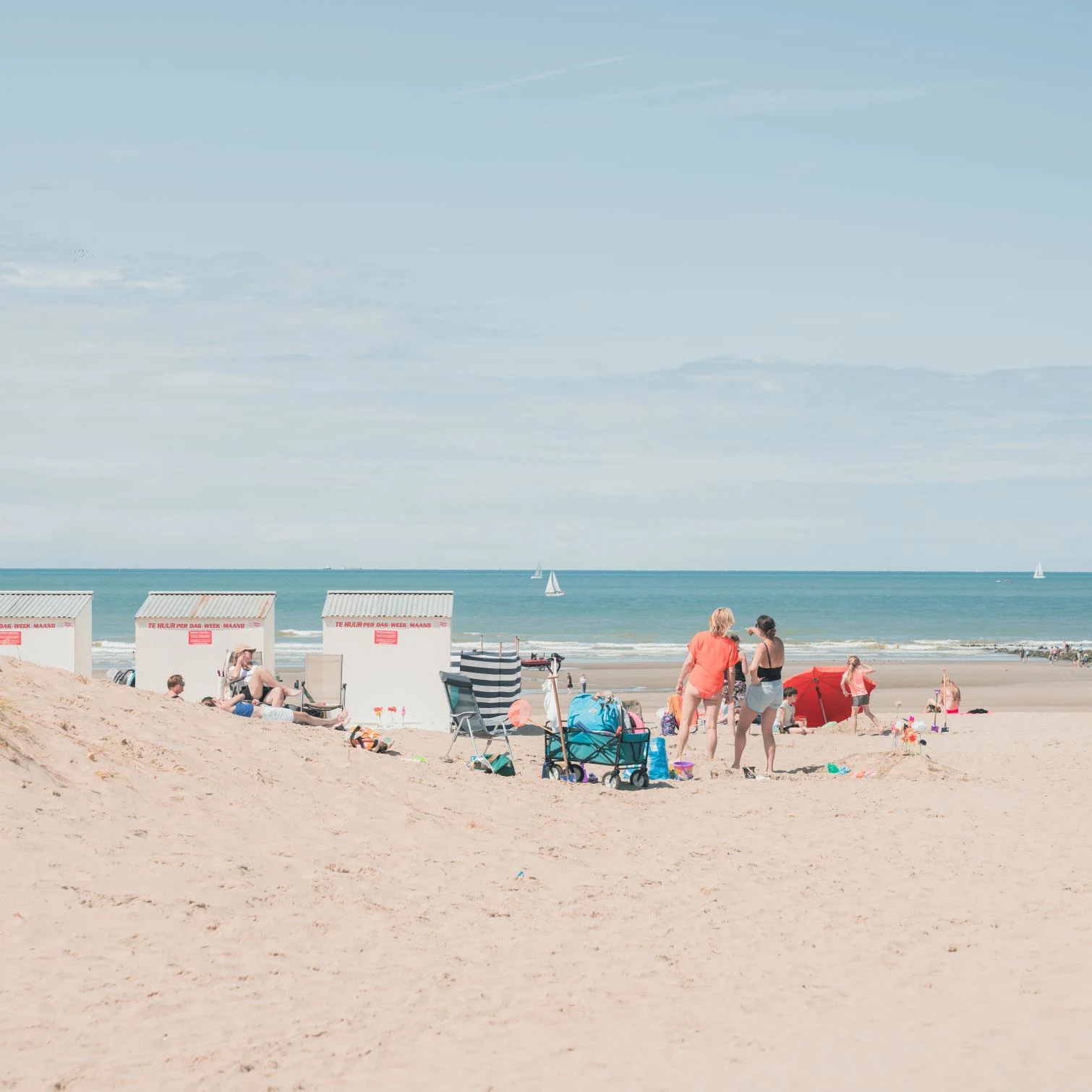 people with surfboards standing next to a beach hut on nieuwpoort beach in belgium