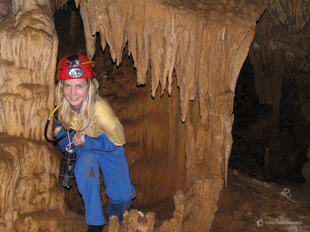 a woman wearing a hard hat underneath stalactites in modric cave near zadar croatia
