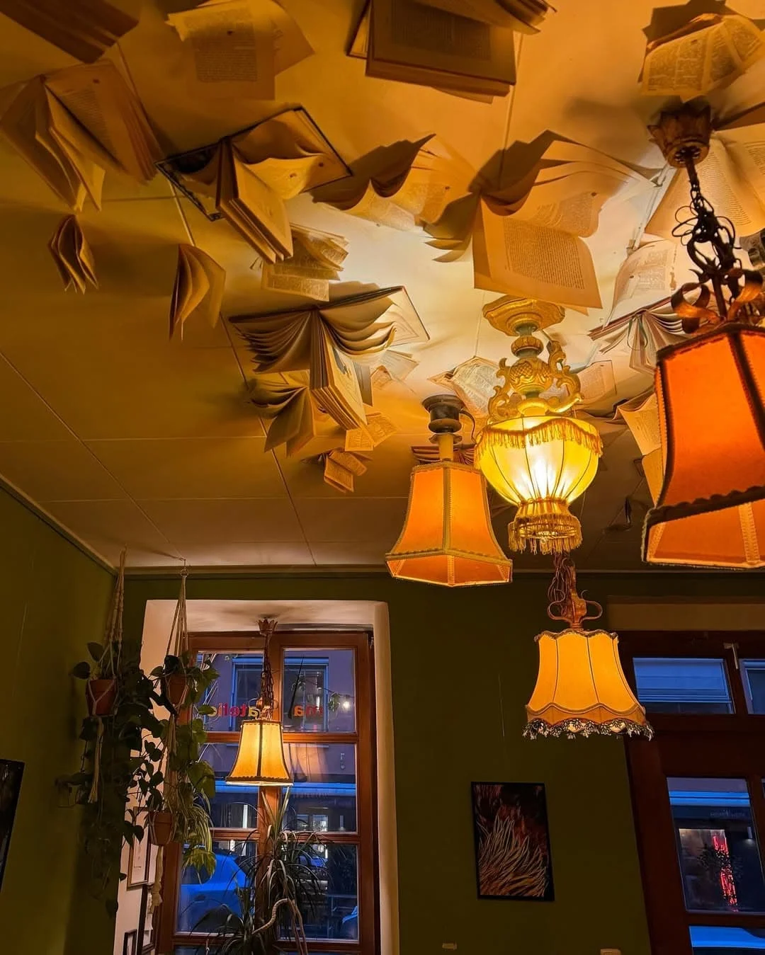 Books and lampshades hanging from the ceiling