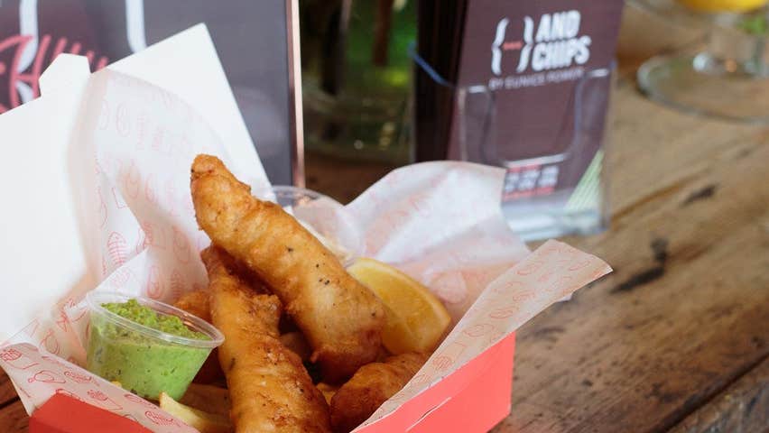 a portion of fish and chips with mushy peas in a takeaway box from andchips in dungarvan ireland
