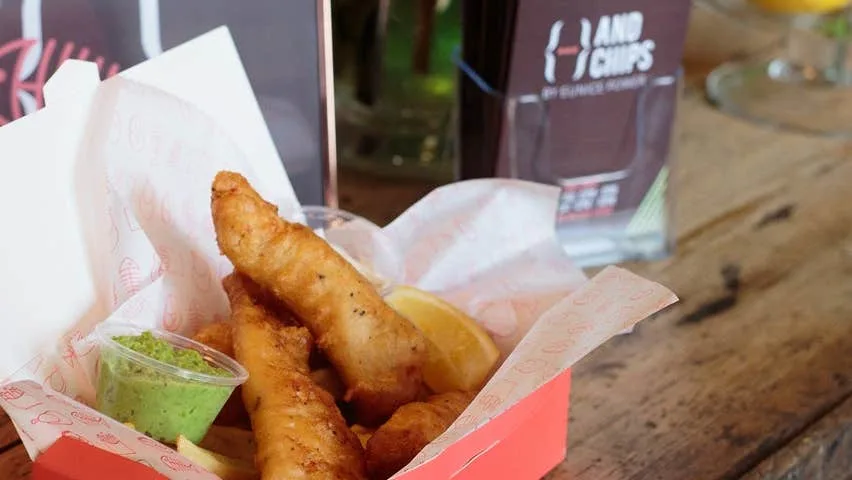 a portion of fish and chips with mushy peas in a takeaway box from andchips in dungarvan ireland