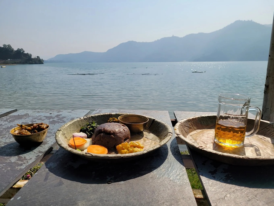 Plates of Nepalese meals overlooking a lake